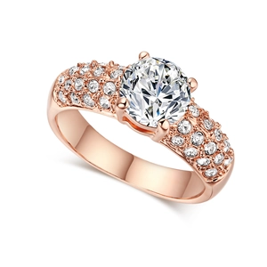 Détail macro d'une bague en or rose avec grand solitaire et pavage de zircons cubiques