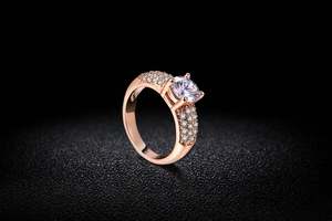 Détail de la bague en or rose avec pierre ronde et sertissage à quatre griffes