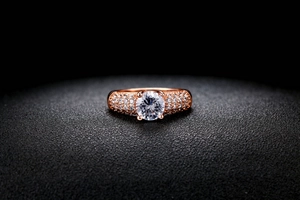 Vue détaillée d'une bague de fiançailles en or rose avec zircon rond et pavé