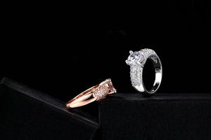 Gros plan des bagues en or rose et argent avec cristaux ronds et diamants pavés