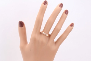 Nahaufnahme eines roségoldenen Rings mit Kreuzlinien und Zirkonia-Besatz am Modell