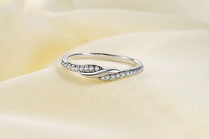 Nahaufnahme des silbernen Rings mit Zirkonia-Besatz auf weich strukturiertem Hintergrund
