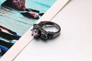 Macro shot of gothic black skull ring with purple zircon and spinal bone details