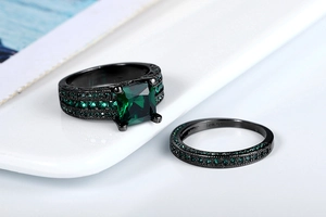 Macro view of 10K black gold plated ring set featuring emerald cut green zircon stones