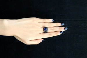 Detail van een zwartgouden dubbellaagse ring met diepblauwe saffier en zirkonia-micropave