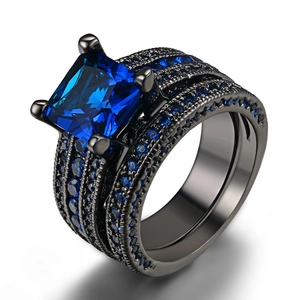 Close-up of black plated double ring set featuring square blue cubic zirconia stones
