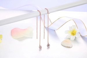 Dettaglio degli orecchini a filo a spirale in oro rosa con pendenti a goccia in zircone