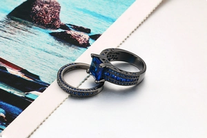 Detail of black gold double ring set with square blue zircon and pavé micro-inlay