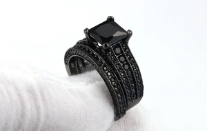 Detail of black gold ring set featuring princess cut blue zircon and pavé crystals