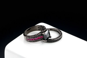 Detail of 18K engraved black gold ring set featuring a square black gemstone and red zircons