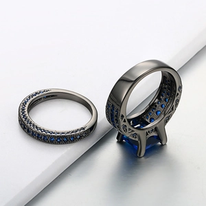 Black gold two-piece ring set with square blue zircon and pavé crystals on grey background