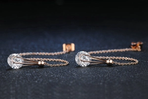 Macro di orecchini a onde in oro rosa con grandi pietre di zircone rotonde e brillanti