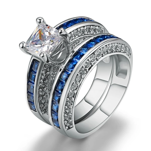 Macrodetail van zilveren ringenset met prinsesgeslepen steen en blauwe spinel zijstenen