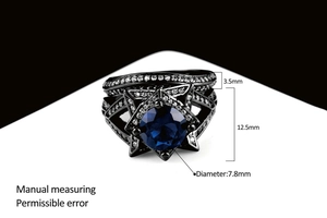 Macro-opname van zwart vergulde dubbele ringen set met blauwe steen en witte zirkonias