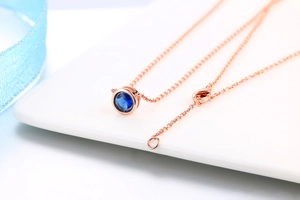 Dettaglio macro del ciondolo in zaffiro blu placcato oro rosa con catena a O