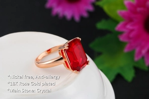 Detail of red emerald-cut crystal ring with 18K rose gold plating and four-prong setting