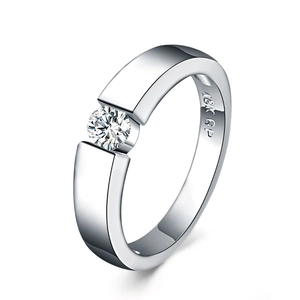 Macro shot of silver ring with 18K GP engraving and tension-set round diamond stone