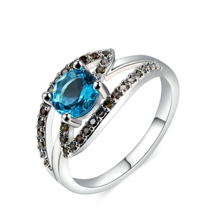 Macro view of blue zircon ring with white gold plating and champagne side stones