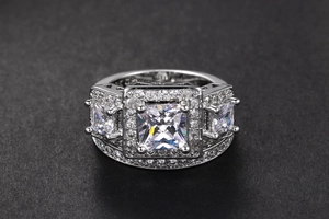 Detalle de anillo plateado con piedra central cuadrada y pavé de circonitas brillantes