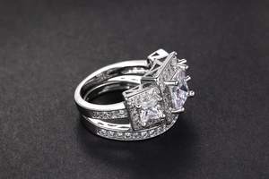 Detalle de anillos dobles de plata con tres circonitas de corte cuadrado elegante