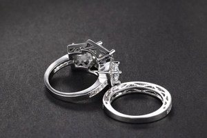 Vista detallada de un conjunto de anillos de boda de plata con circonita cuadrada halo