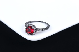 Detail view of the 18K GP engraving inside the red zircon halo engagement ring band