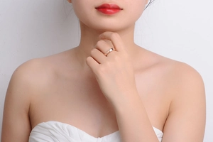 Close-up of a rose gold ring with a single solitaire diamond on a model's finger
