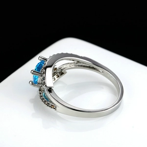 Blue zircon silver ring with oval centerpiece and micro-pave crystals on black background