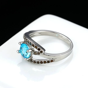 Blue zircon silver ring with bifurcated band and micro-pave accents on white display