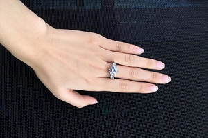 Detailed view of women's sparkling AAA zircon ring with round cut center and side stones