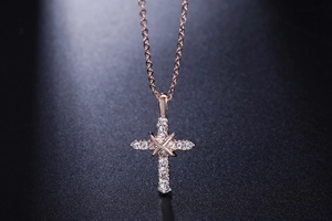 Dettaglio della collana con pendente a croce in oro rosa con zirconi micro-pave
