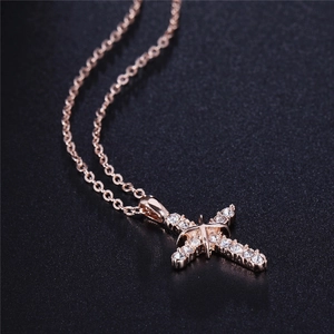 Collana con ciondolo a croce in oro rosa e zirconi brillanti su superficie nera