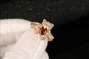 Detailweergave van roségouden berenring met hartvormige rode zirkoon en pavé-stenen