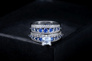 Macro view of square-cut clear gemstone and blue zircon pavé on white gold ring set