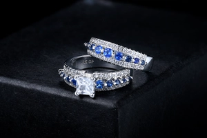 Macro detail of 18K GP engraving on white gold rings with blue and white zircon