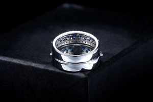 Detailed macro view of silver ring band with blue zircon stones and honeycomb metal interior