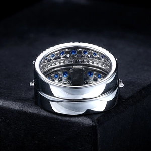 Elegant silver layered ring with blue zircon stones displayed on a black podium