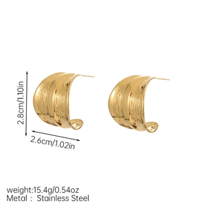 Macro detail of large gold C-shape earrings in stainless steel with wavy hammered texture