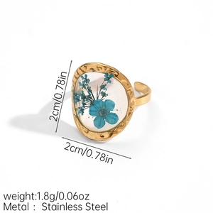 Detailed macro view of an adjustable gold stainless steel ring with blue dried flowers