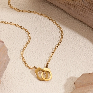 Polished 18K gold-plated handcuff pendant necklace with O-chain on textured background