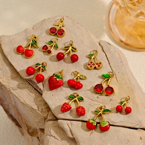 Aardbei- en kersenhangers van titaniumstaal met rood emaille op een natuurlijke steen