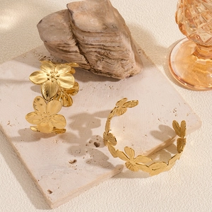 Vintage golden flower titanium steel open bracelets on an elegant marble surface
