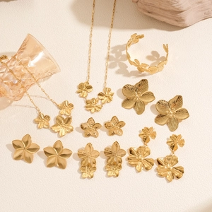 Golden floral jewelry set with necklaces, earrings, and bracelet in brushed matte finish