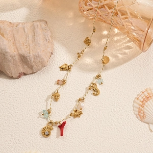 Bohemian ocean theme necklace with starfish shell and pearl pendants on sandy texture