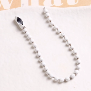 Macro detail of white painted metal bead chain with connector for DIY crafts and hanging