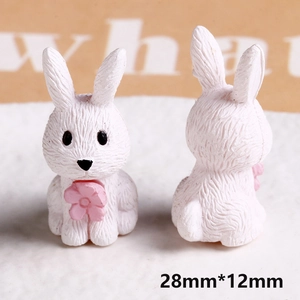 Detail of mini resin rabbit figurines showing white hair texture and pink flower accents