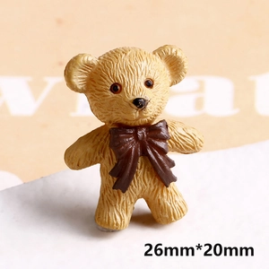 Macro shot of 26mm x 20mm yellow resin bear figurine with brown bow and fur texture