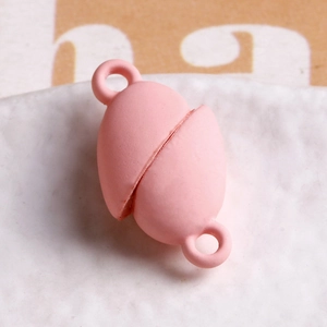Macro view of a matte pink heart-shaped magnetic clasp for DIY jewelry making accessories