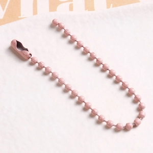 Macro detail of pink speckled metal bead chain with matching connector link