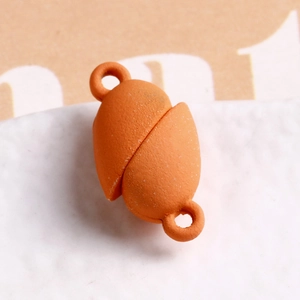 Macro view of orange matte magnetic clasp with dual loops for DIY jewelry making